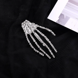 Gothic skull hand hair clip with sparkling rhinestones on black lace background