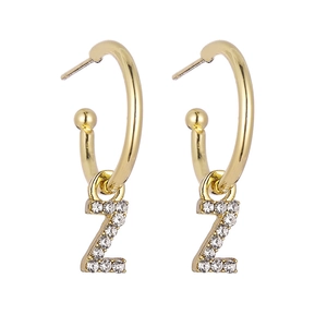 Close-up of gold hoop earrings with sparkling crystal-encrusted letter Z pendants