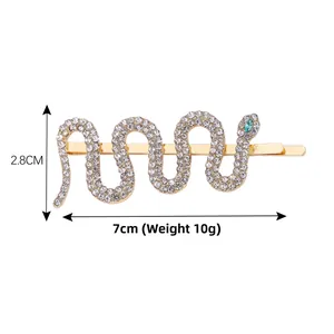 Detailed view of snake-shaped hair clip with white crystals and green rhinestone eyes