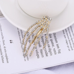 Detailed macro view of gold skeleton hand hair clip with sparkling inlaid rhinestones