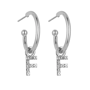 Macro view of silver alphabet F earring with shimmering cubic zirconia stones
