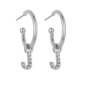 Close-up of silver hoop earrings with sparkling crystal-encrusted letter J pendant charms