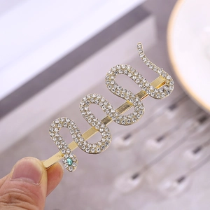 Elegant gold snake hair clip with white crystals and green gemstone eyes for women