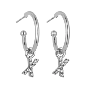 Macro view of silver hoop earrings featuring sparkling crystal-paved letter X pendants