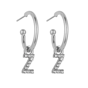 Detailed view of silver C-shaped hoop earrings with diamond-encrusted letter Z pendant