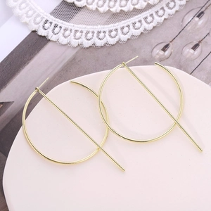 Minimalist gold geometric hoop earrings with vertical metal bar on ceramic tray