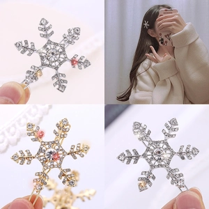 Detailed view of silver and gold snowflake hair clips with sparkling crystal rhinestones
