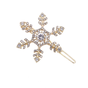 Elegant gold snowflake hair clip featuring sparkling white rhinestones on white background