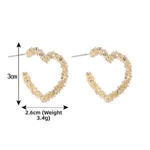 Vue détaillée des boucles d'oreilles cœur dorées texturées mesurant 3cm par 2,6cm