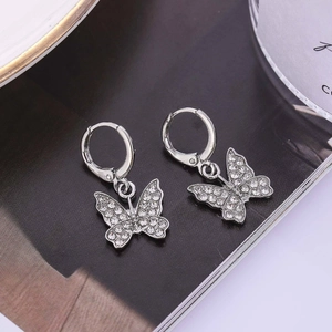 Boucles d'oreilles papillon argentées avec cristaux étincelants sur fond sombre