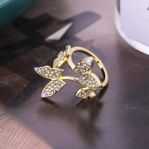 Elegant gold butterfly open ring with sparkling crystal pavé on dark background