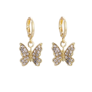 Élégantes boucles d'oreilles papillon dorées avec cristaux blancs sur fond blanc
