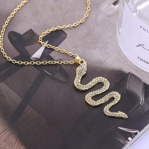 Creative gold-colored snake pendant necklace featuring sparkling white rhinestones