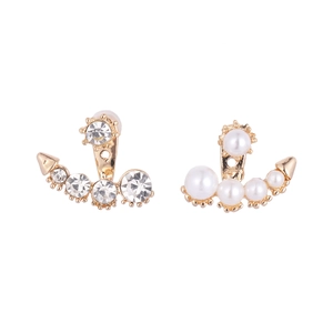 Boucles d'oreilles dorées incurvées avec strass et perles asymétriques sur fond blanc