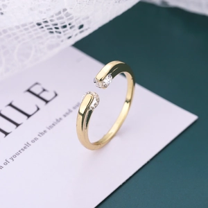 Macro detail of elegant gold-tone copper ring featuring two brilliant round cubic zirconia