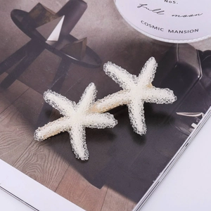 Pair of white starfish hair clips with sugar crystal texture on gold metal duckbill base