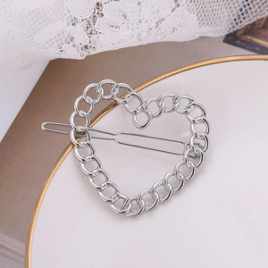 Pince à cheveux cœur en métal argenté avec maillons de chaîne sur porcelaine