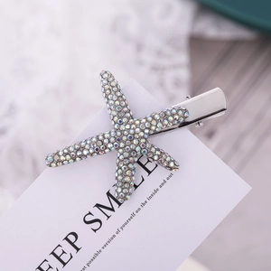Macro detail of silver starfish hair clip with rainbow rhinestones and metal base