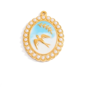 Golden oval pendant featuring white pearl border and blue enamel swallow motif
