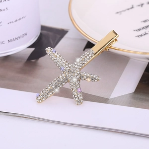 Detailed macro view of starfish hair clip with sparkling crystals and golden metallic base