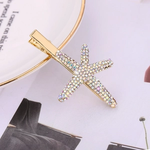 Detailed close-up of a starfish hair clip with rainbow rhinestones on a ceramic plate