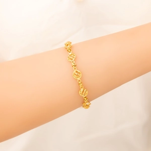 Elegante bracciale dorato con maglie circolari traforate mostrato sul polso
