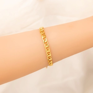 Dettaglio del bracciale a catena cubana dorata con ciondoli a cuore e chicchi di caffè