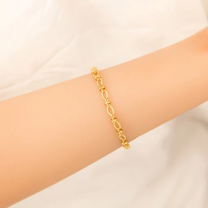 Detailed close-up of a 18K gold-plated wavy chain bracelet with textured oval links