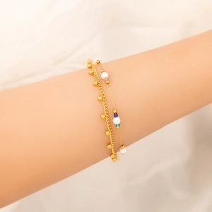 Dettaglio del set di bracciali a doppio strato in oro 18K con perle e perline di vetro blu