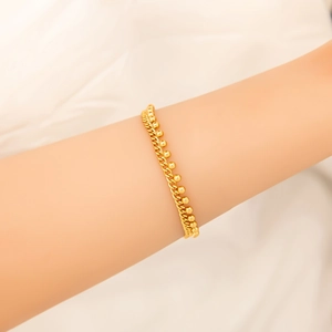 Detail of 18K gold double layer bracelet featuring sleek beads and twisted rope chain