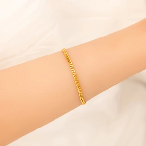 Detailed macro view of an 18K gold-plated stainless steel chain bracelet on a wrist