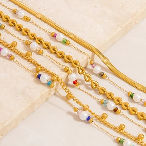 Bracciale a doppio strato in oro 18K con perle, maglie a cuore e ciondoli a stella