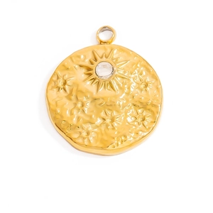 Détail d'un pendentif rond doré avec motif soleil et pierre de cristal centrale
