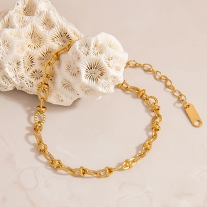 Minimalist 18K gold plated stainless steel bracelet with twisted oval links on marble