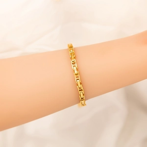 Detail of 18K gold-plated stainless steel chain bracelet on a person's wrist