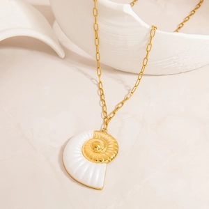 Detailed close-up of a nautilus shell pendant in gold and white on an oval link chain