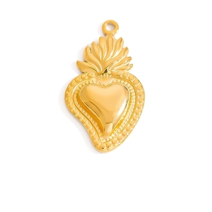Primer plano detallado de un colgante de corazón dorado con llamas y textura en relieve