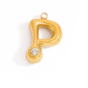 Macro shot of gold letter P pendant featuring a sparkling zircon stone and polished finish