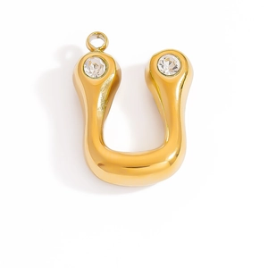 Detailed macro view of 18K gold horseshoe pendant with clear cubic zirconia stones