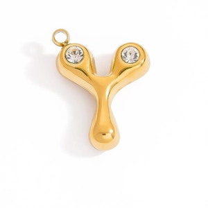 Macro shot of 18K gold letter Y pendant with two sparkling crystals and water-drop texture