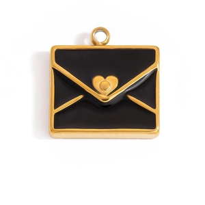 Detalle de un colgante de sobre dorado con esmalte negro y sello de corazón vintage