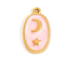 Detalle de un colgante ovalado chapado en oro con esmalte rosa y motivos de estrella y luna
