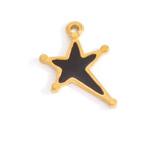 Detalle macro de un colgante de estrella en acero dorado con esmalte negro y perlas
