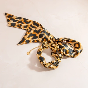 Leopard Seidenschal Armband mit 18K Goldkette und Herzanhänger auf Marmorhintergrund