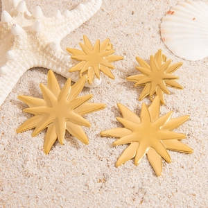 Set di gioielli con ciondolo a stella solare dorata su sabbia bianca e conchiglie