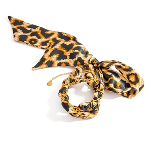 Detail von Leopardenmuster-Seidenschal-Armband mit Goldkette und Herzanhänger