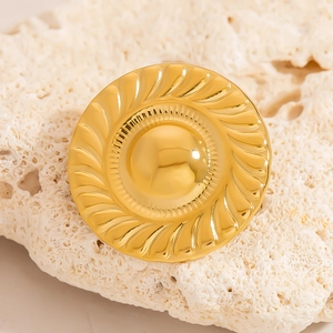 Retro golden mushroom button brooch with spiral relief texture on a white coral stone