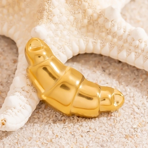 Polished 18K gold-plated croissant brooch for women displayed on white sand