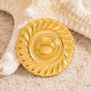 Golden vintage style mushroom brooch with wheat relief texture on sand background