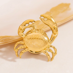 Détail macro d'une broche crabe dorée avec une finition métallique polie et texture précise